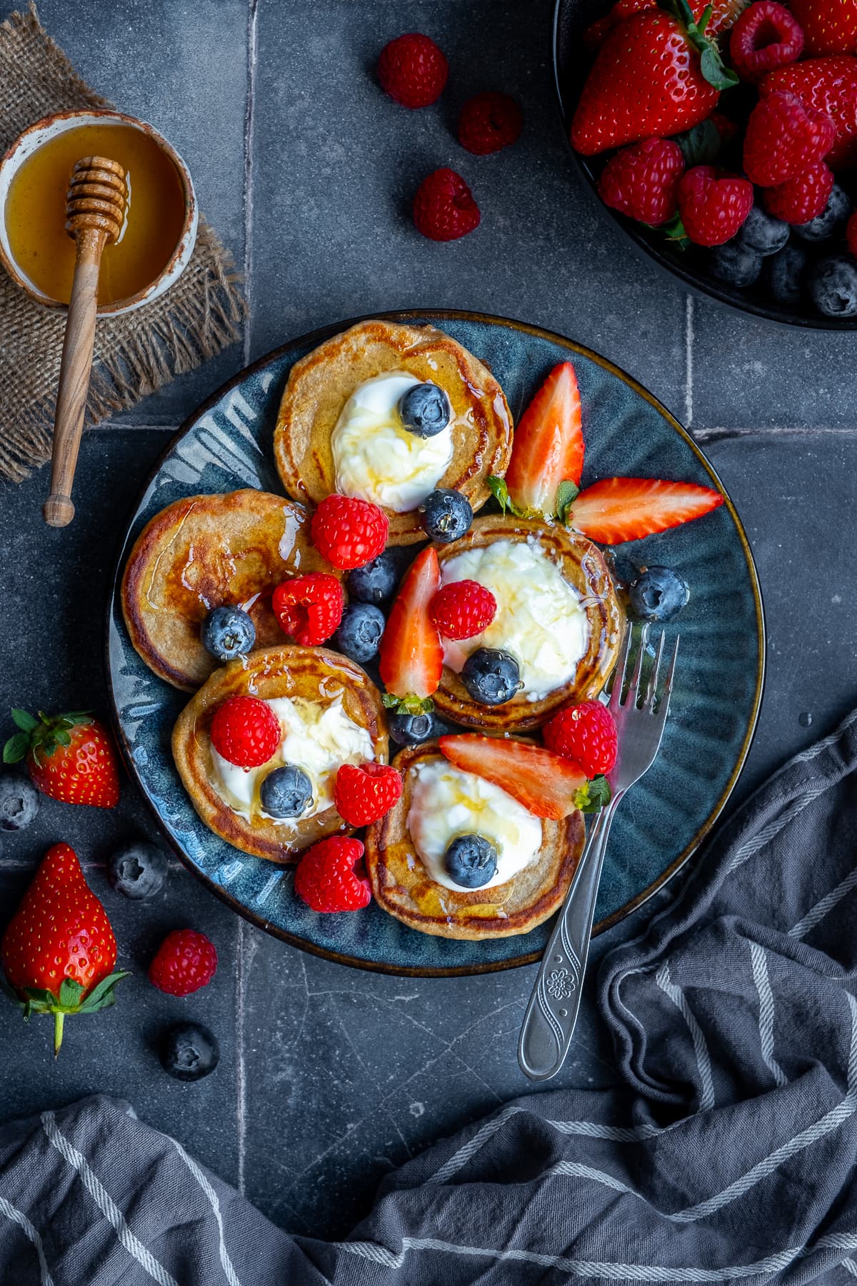 3 Ingredient Banana Oat Egg Pancakes on a plate, topped with yogurt and berries