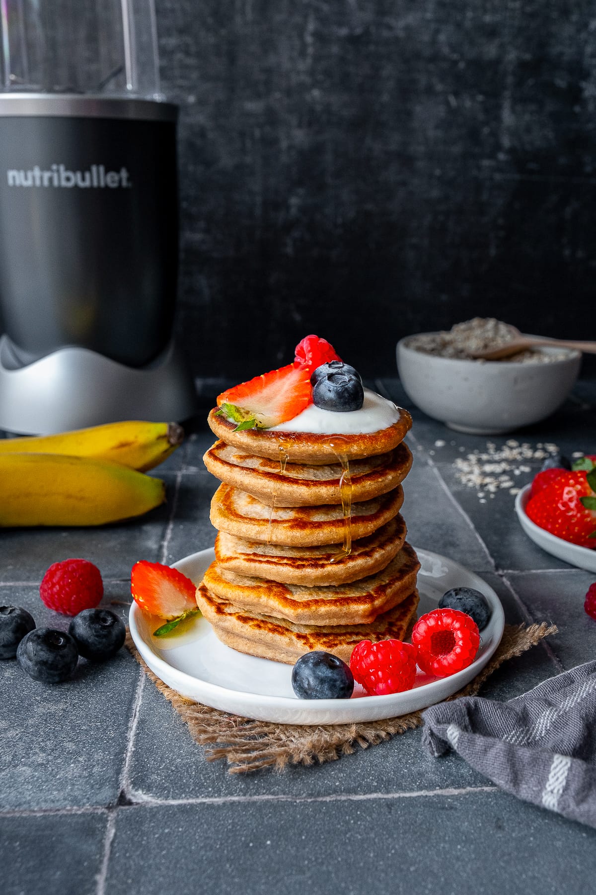 Stack of 6 Banana Oat Egg Pancakes with a Nutribullet in the background.