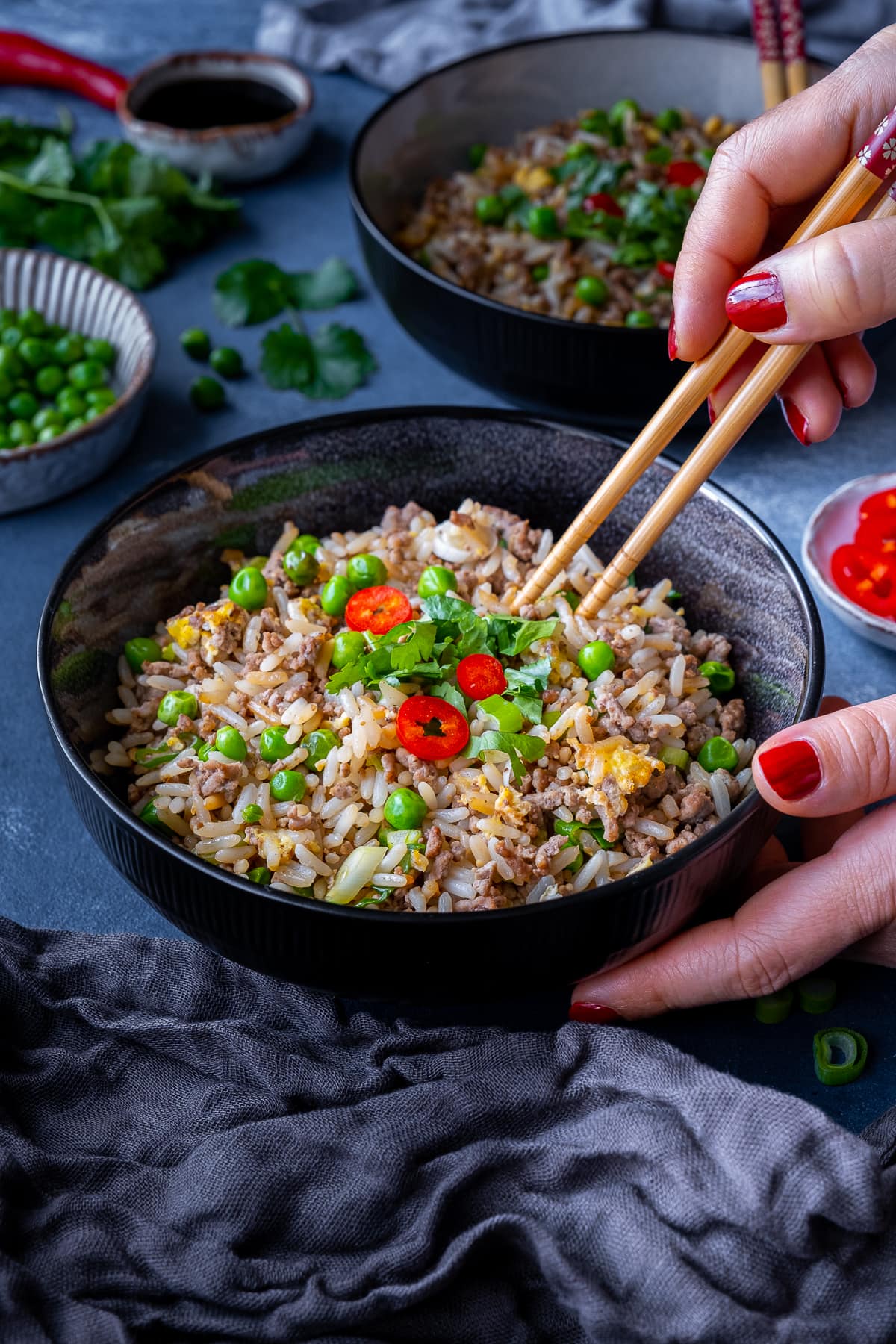 Easy Beef Fried Rice in a bowl, with a woman's hands holding chopsticks