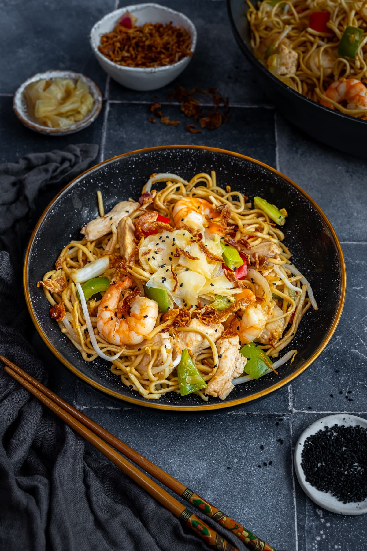 Chicken and Prawn Yaki Soba in a bowl with chopsticks next to the bowl