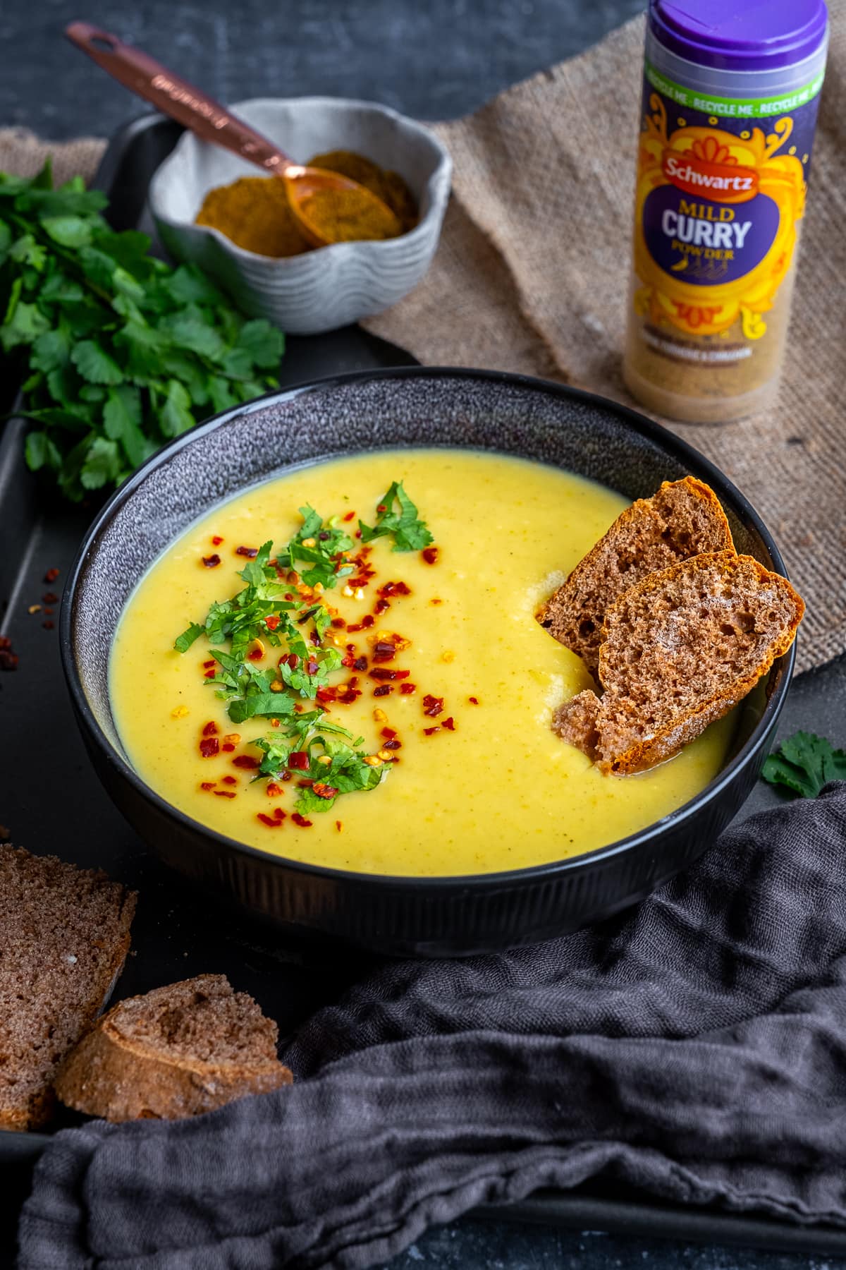 One bowl of Curried Parsnip Soup. Jar of Schwartz Mild Curry Powder in the background.