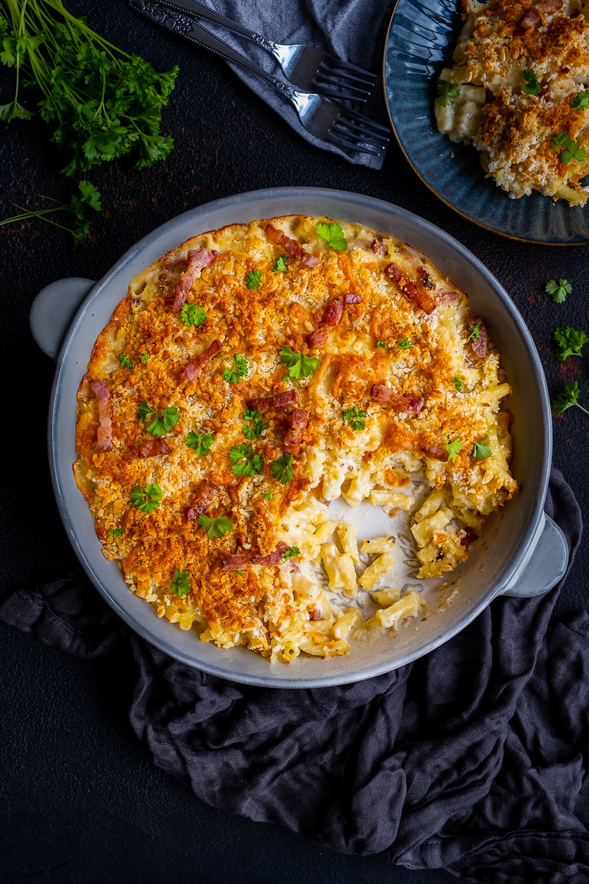 Overhead shot of Easy Bacon Macaroni Cheese in the dish with one portion taken out