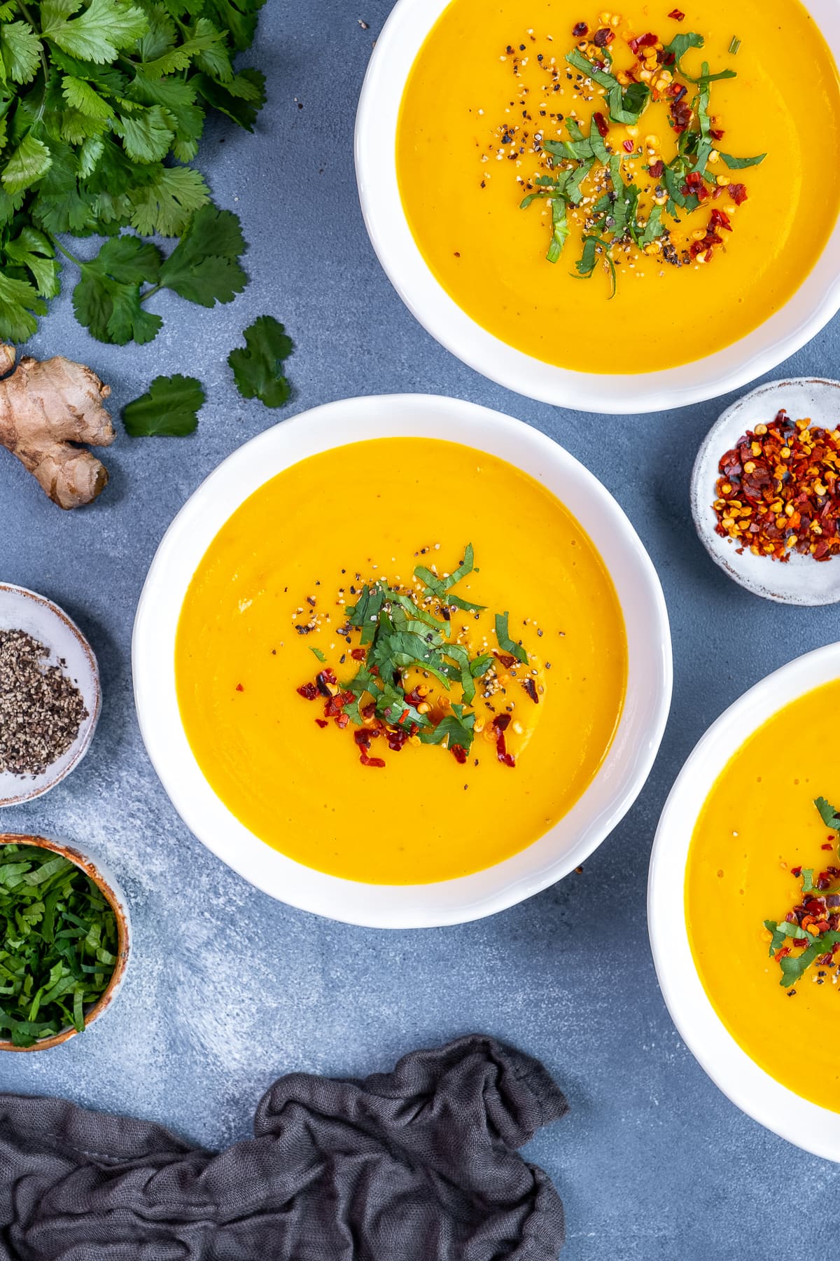 Overhead shot of 3 bowls of Easy Carrot and Parsnip Soup