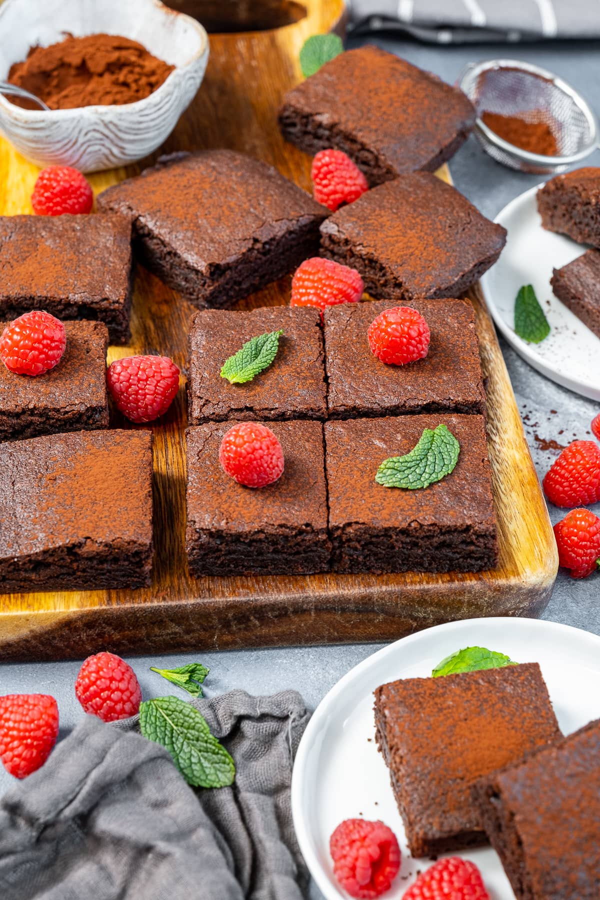 Easy Cocoa Powder Brownies - cut into squares. Shown with raspberries and mint.