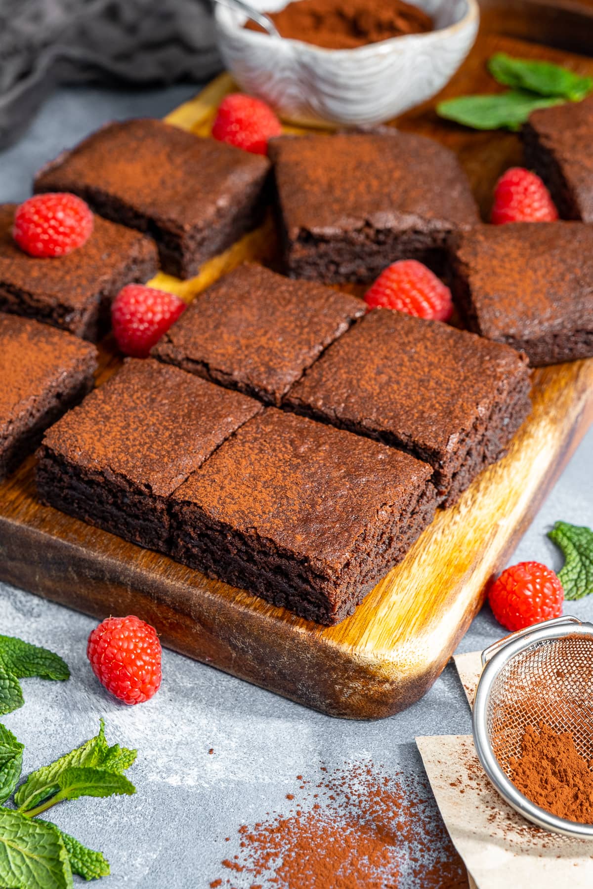 Easy Cocoa Powder Brownies - cut into squares. Shown with raspberries and mint.