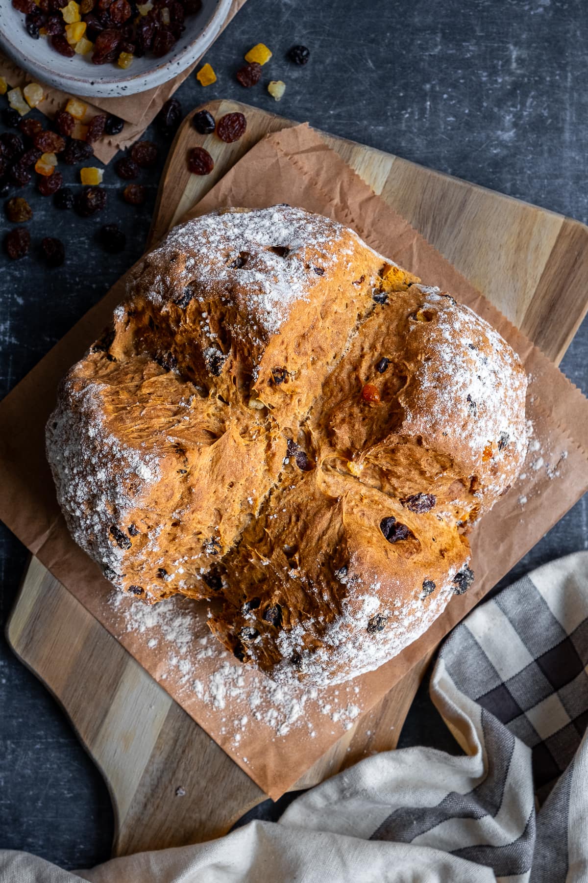 Overhead shot of a loaf of Easy Fruit Soda Bread (uncut) on a wooden board.