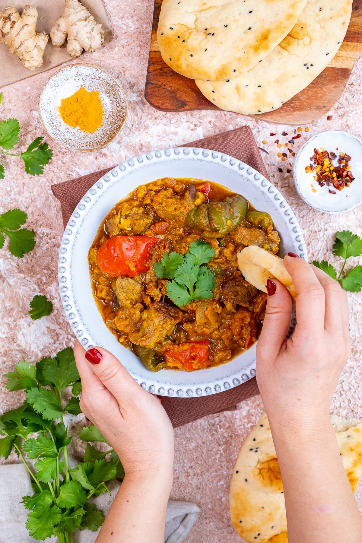 A piece of naan being dipped into Easy Lamb Dhansak