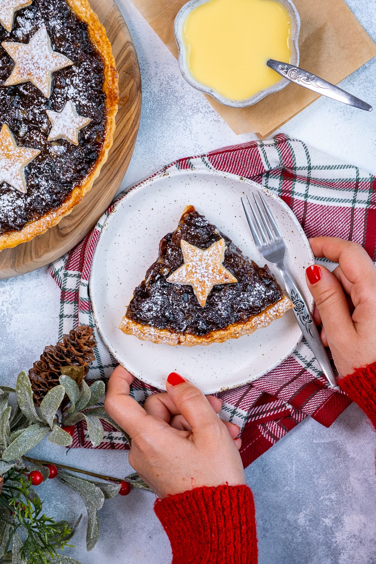 Woman's hands holding 1 piece of Easy Mincemeat Tart up to the camera