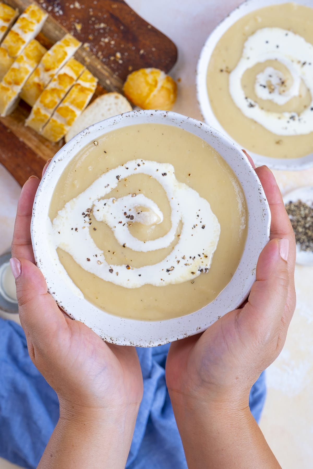 Easy Peasy Parsnip Soup in a bowl, being held up to the camera