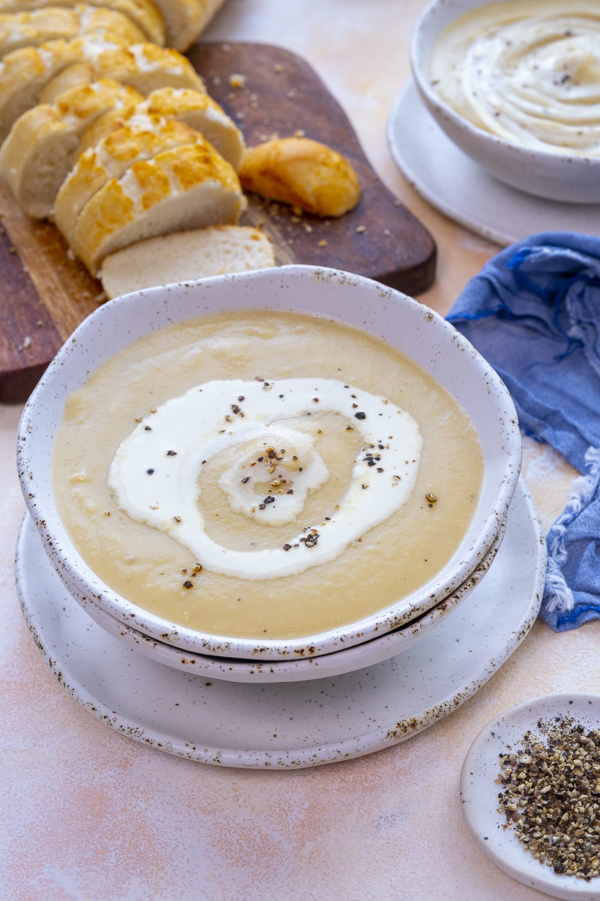 Easy Peasy Parsnip Soup in a bowl in front of a sliced french stick