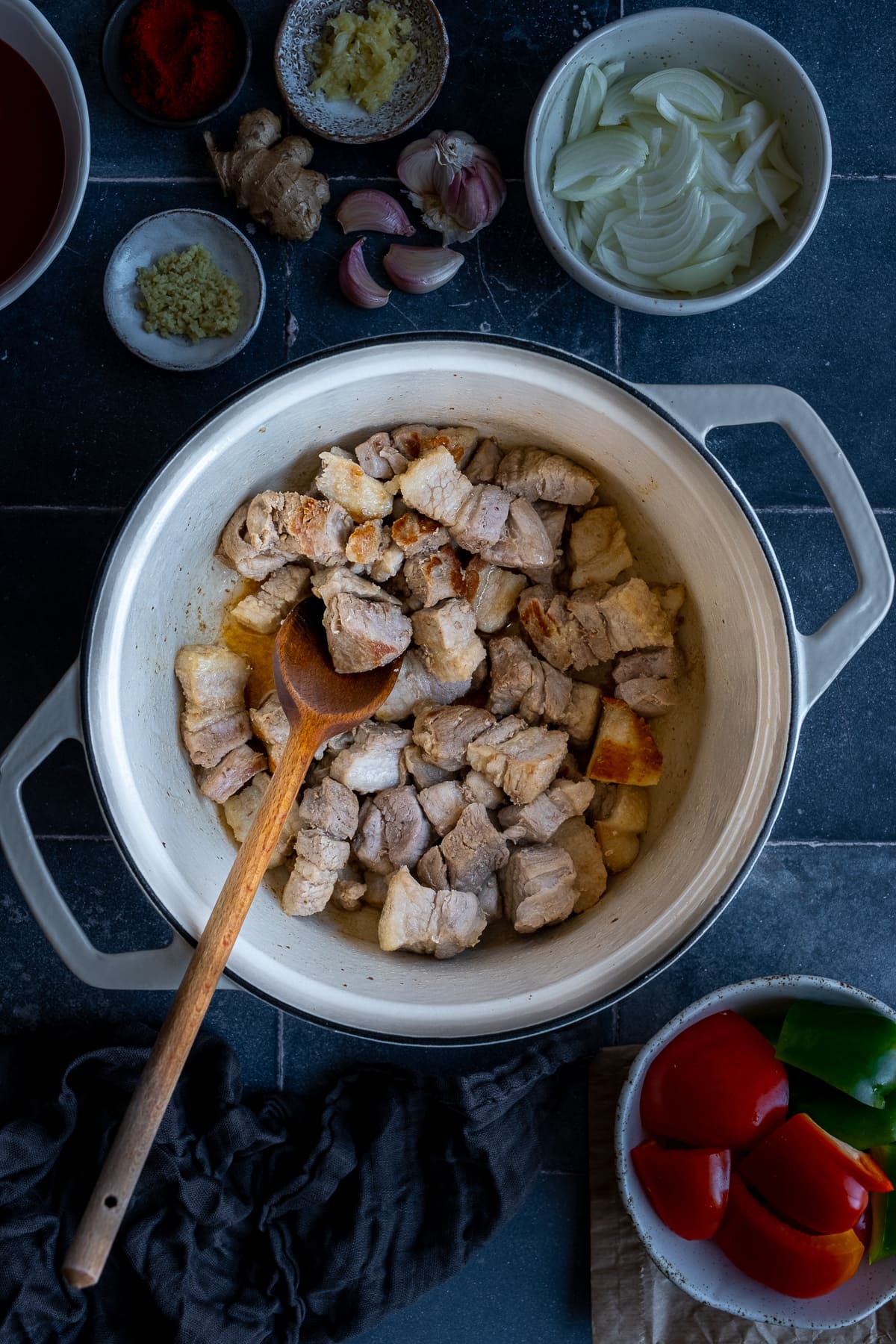 Belly pork being fried in a cast iron pot