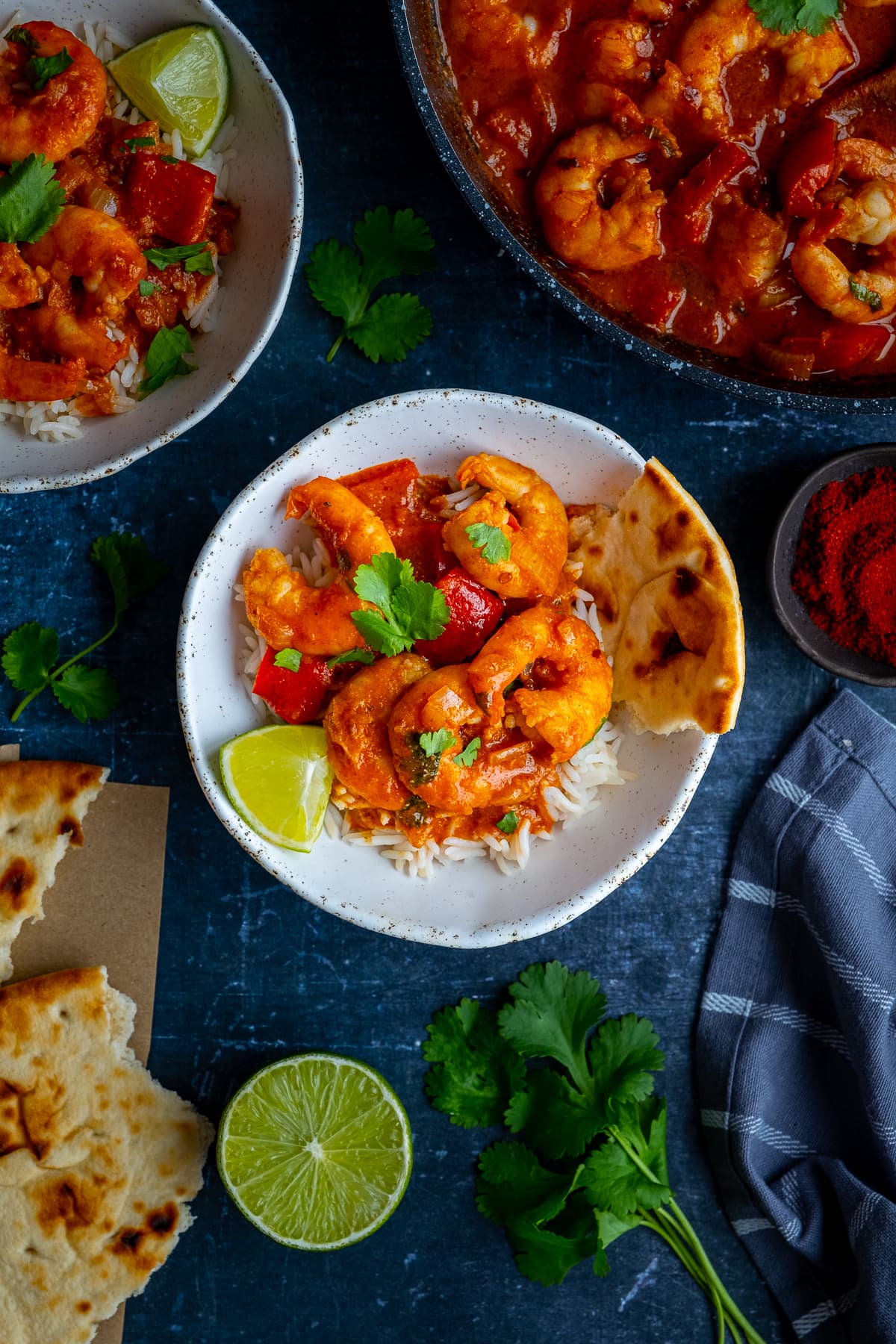 Overhead shot of Easy Prawn Tikka Masala in a bowl with naan bread and rice