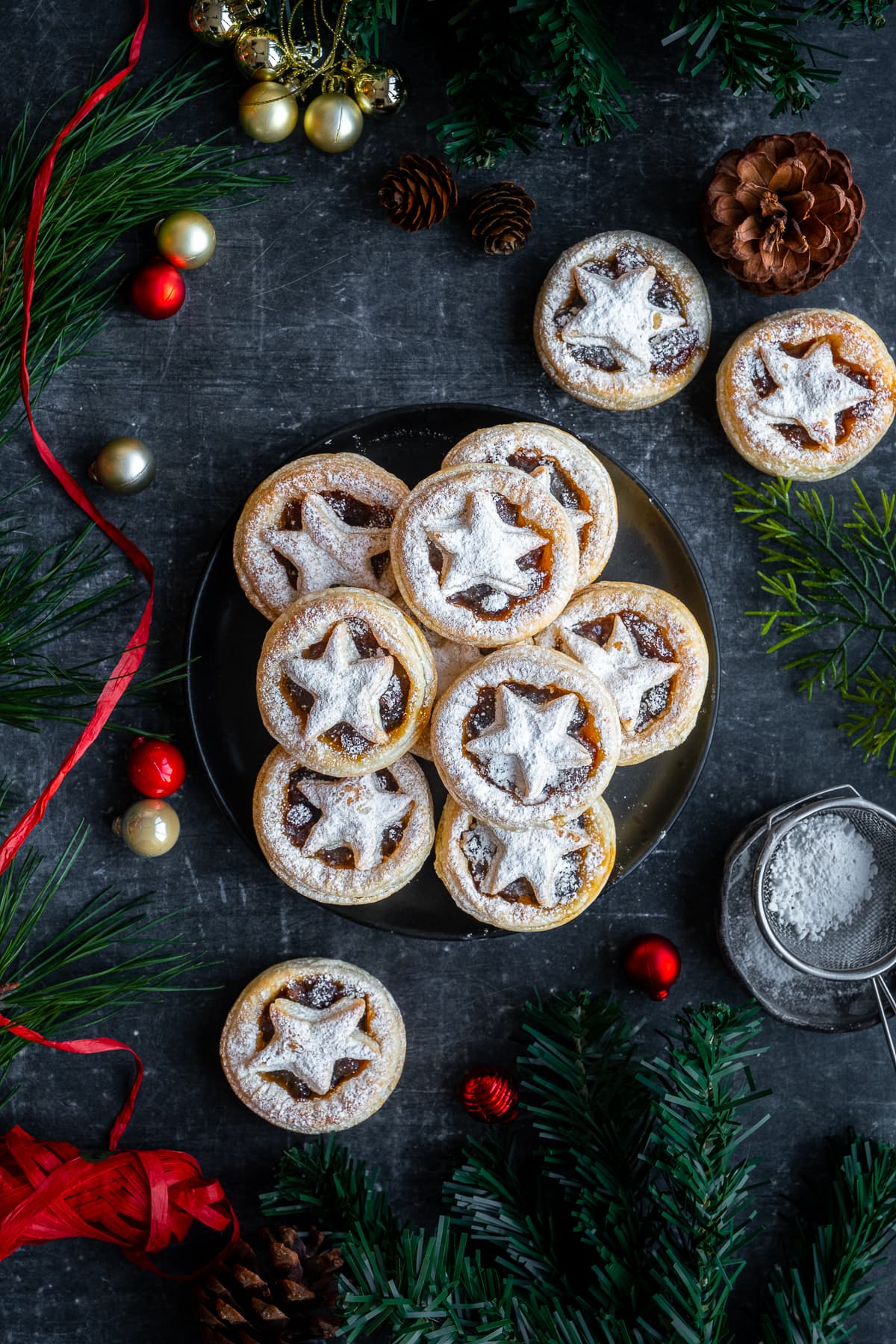 Easy Puff Pastry Mince Pies on and around a plate with Christmas decorations