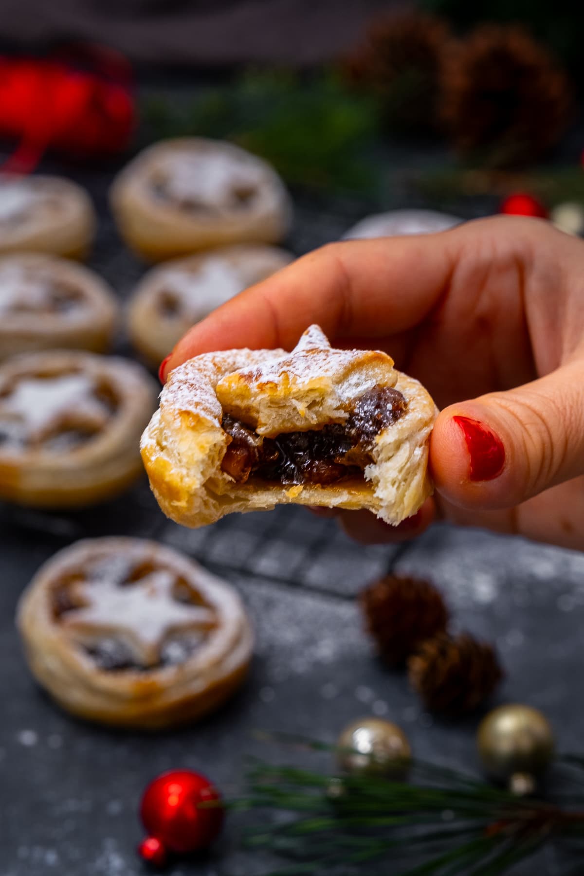 Puff Pastry Mince Pie with a bite out being held up to the camera