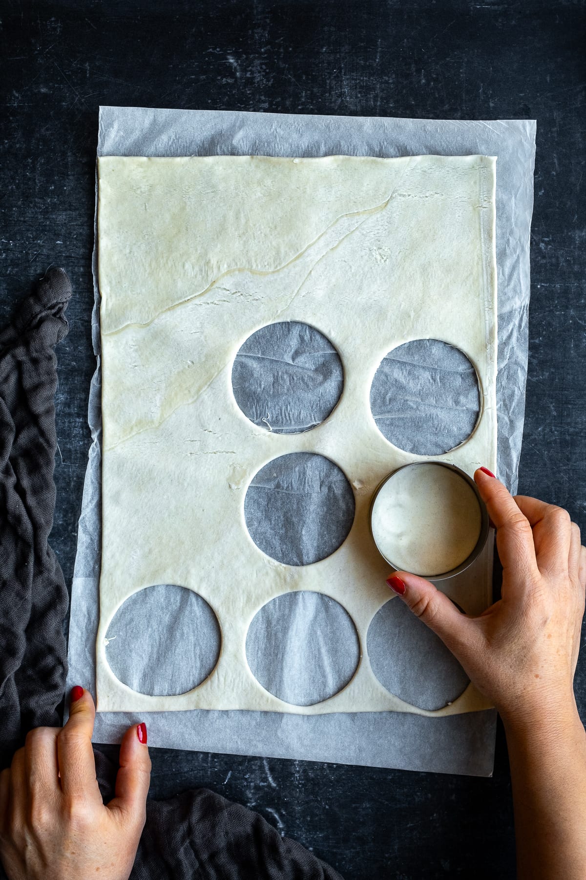 Cutting circles of puff pastry from a ready-rolled puff pastry sheet to make mince pies