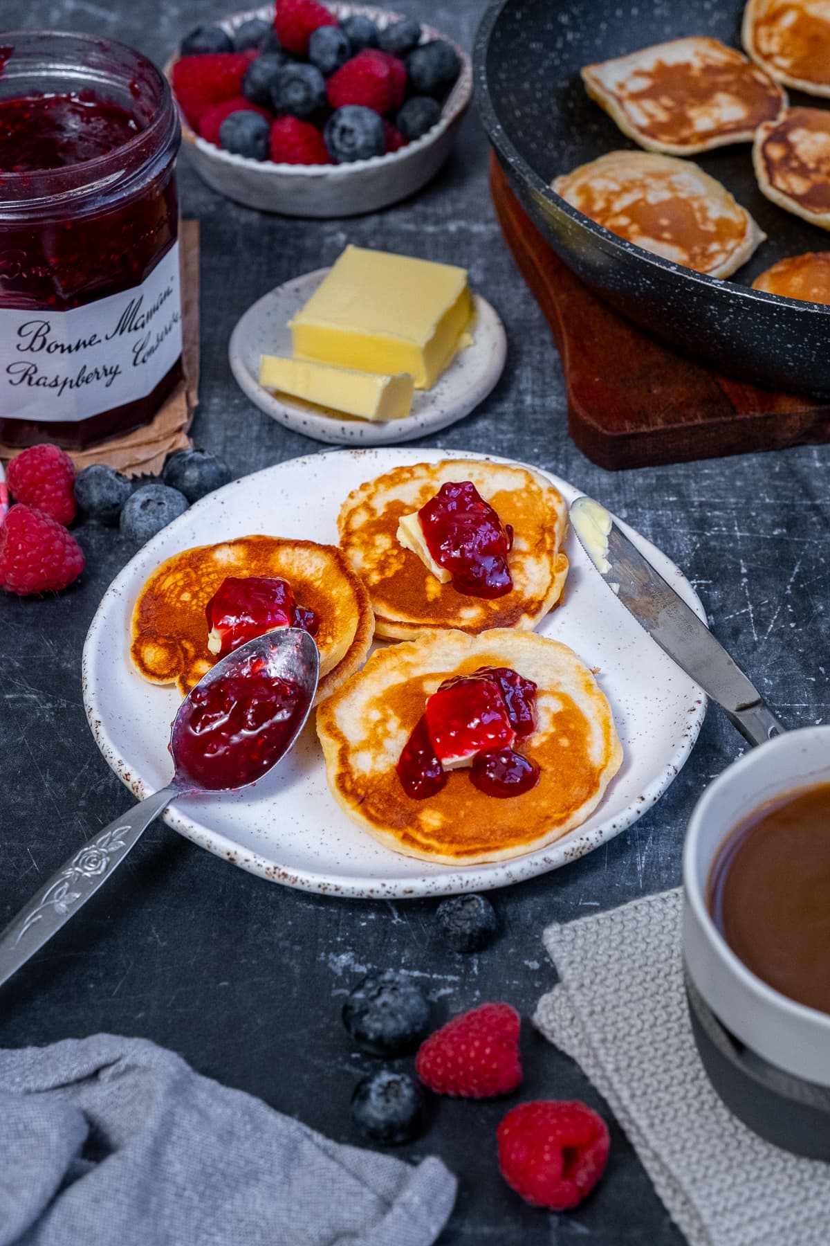 Easy Scotch Pancakes topped with jam and butter.