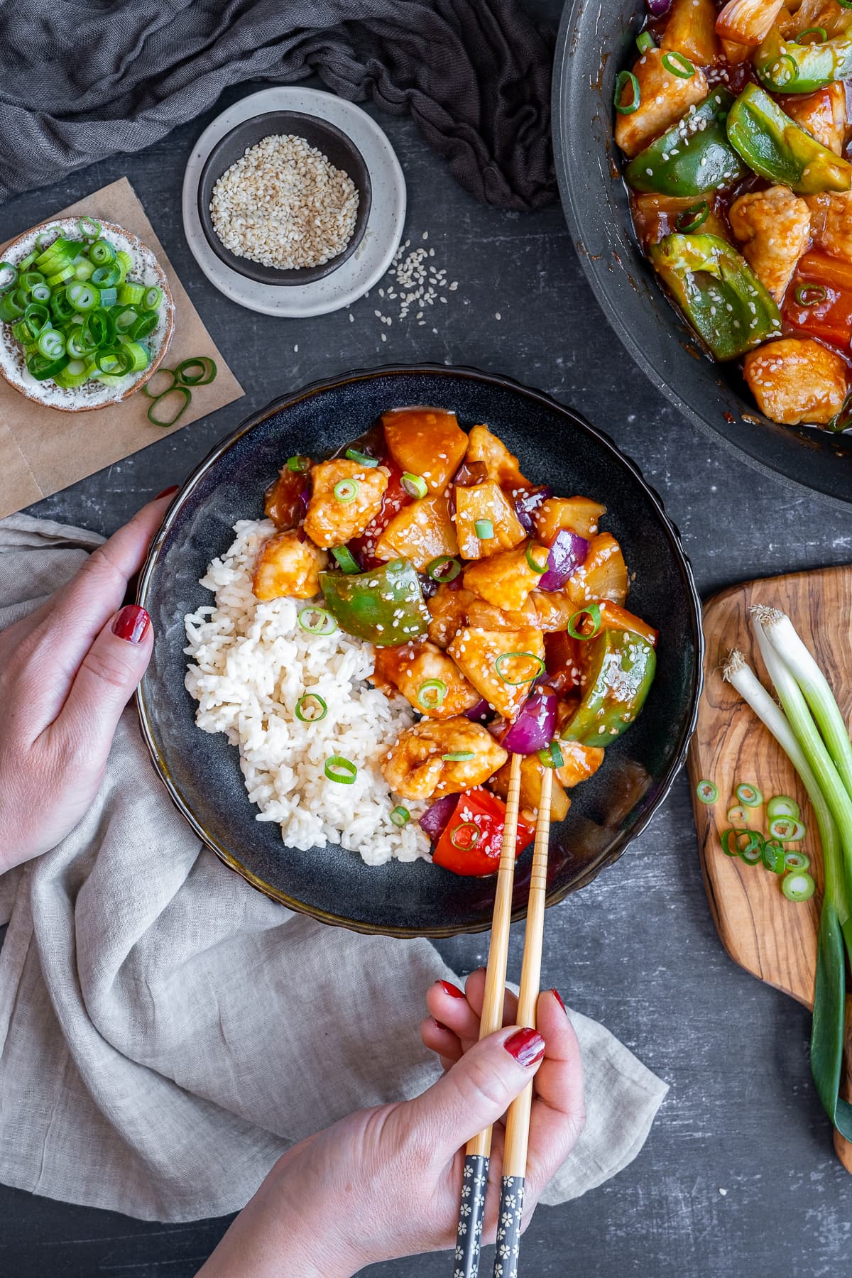 Overhead shot of Woman's hands using chopsticks to eat Easy Sweet and Sour Chicken