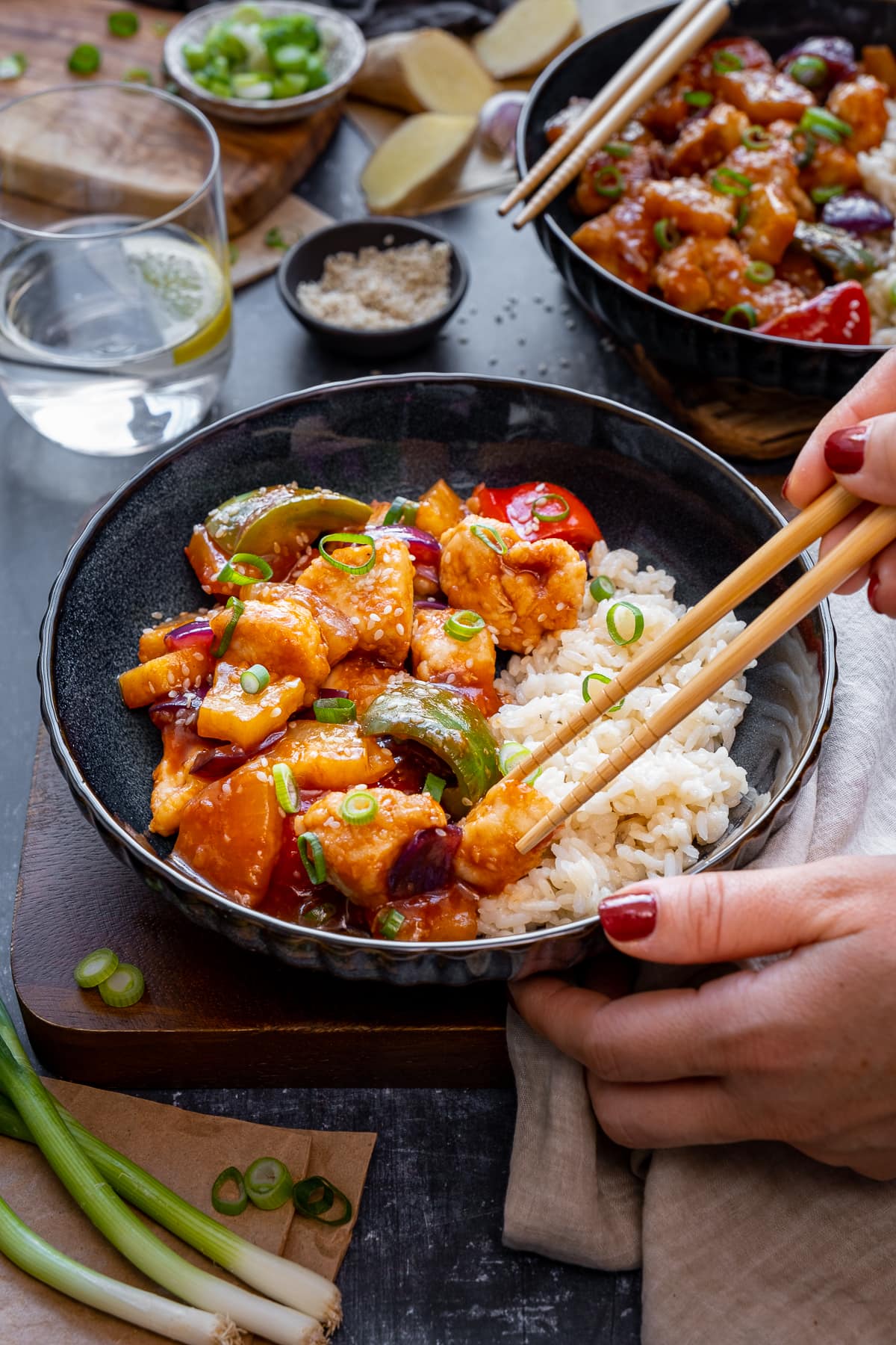 Woman's hands using chopsticks to eat Easy Sweet and Sour Chicken