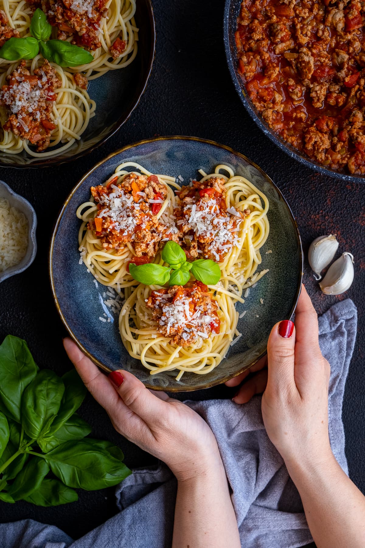 Overhead shot of Easy Turkey Mince Bolognese on a plate being helpd by a woman's hands