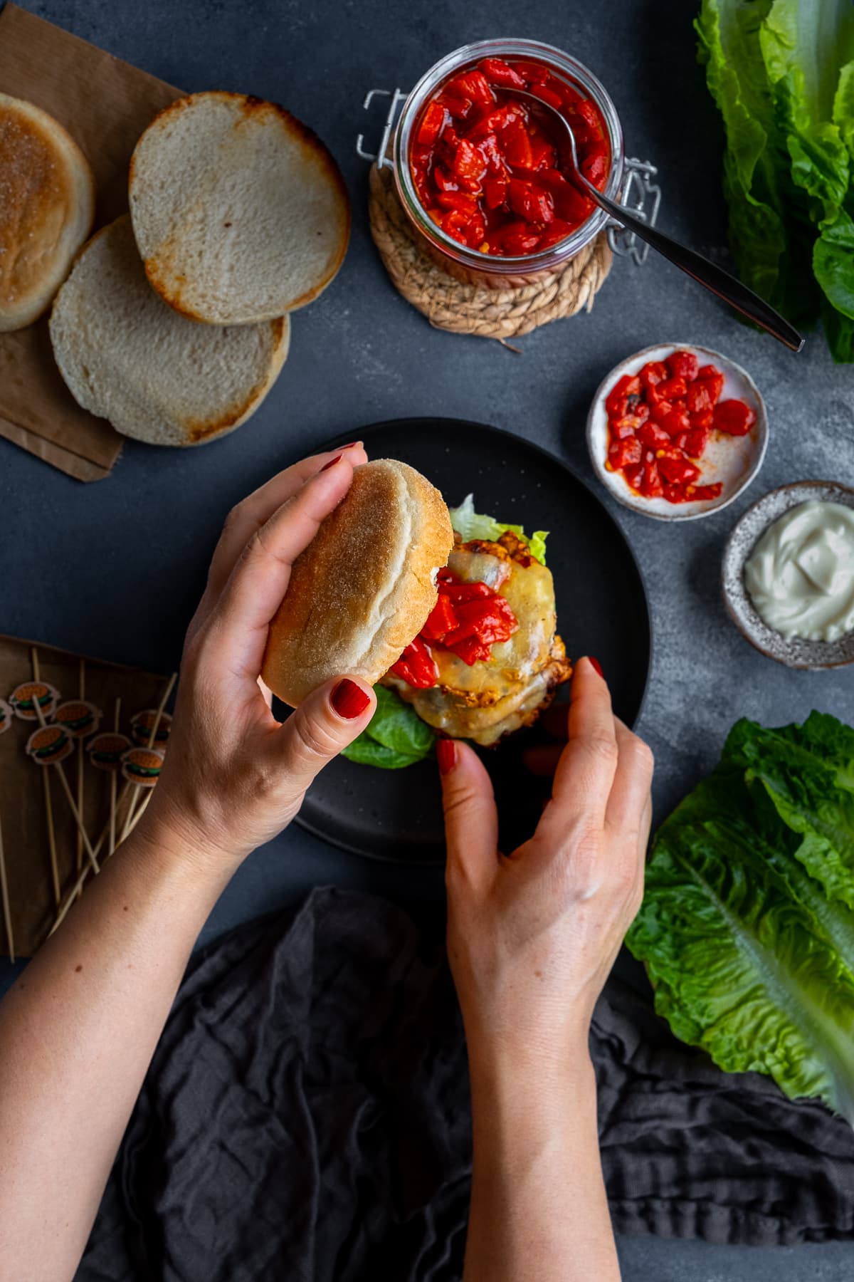 A woman's hands lifting the top of a Homemade Nandos Sunset Burger to show what is inside