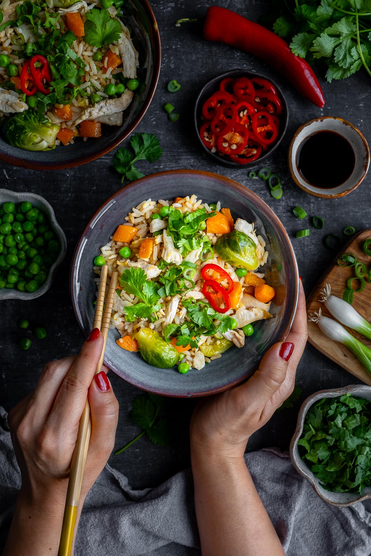 Overhead shot of Woman's hands holding chopsticks eating Leftover Turkey Fried Rice 