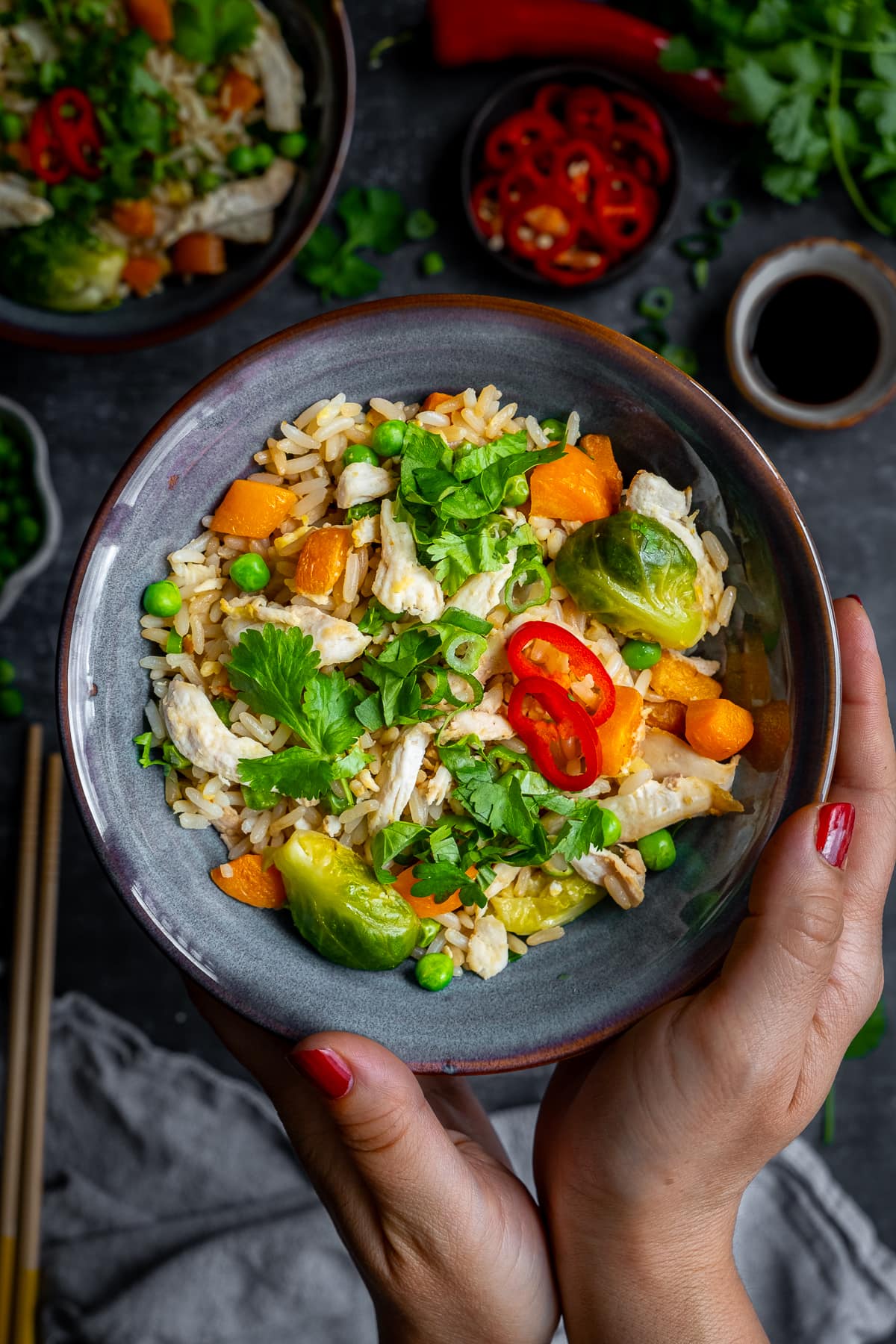 Overhead shot of Leftover Turkey Fried Rice in a bowl being held by a woman's hands