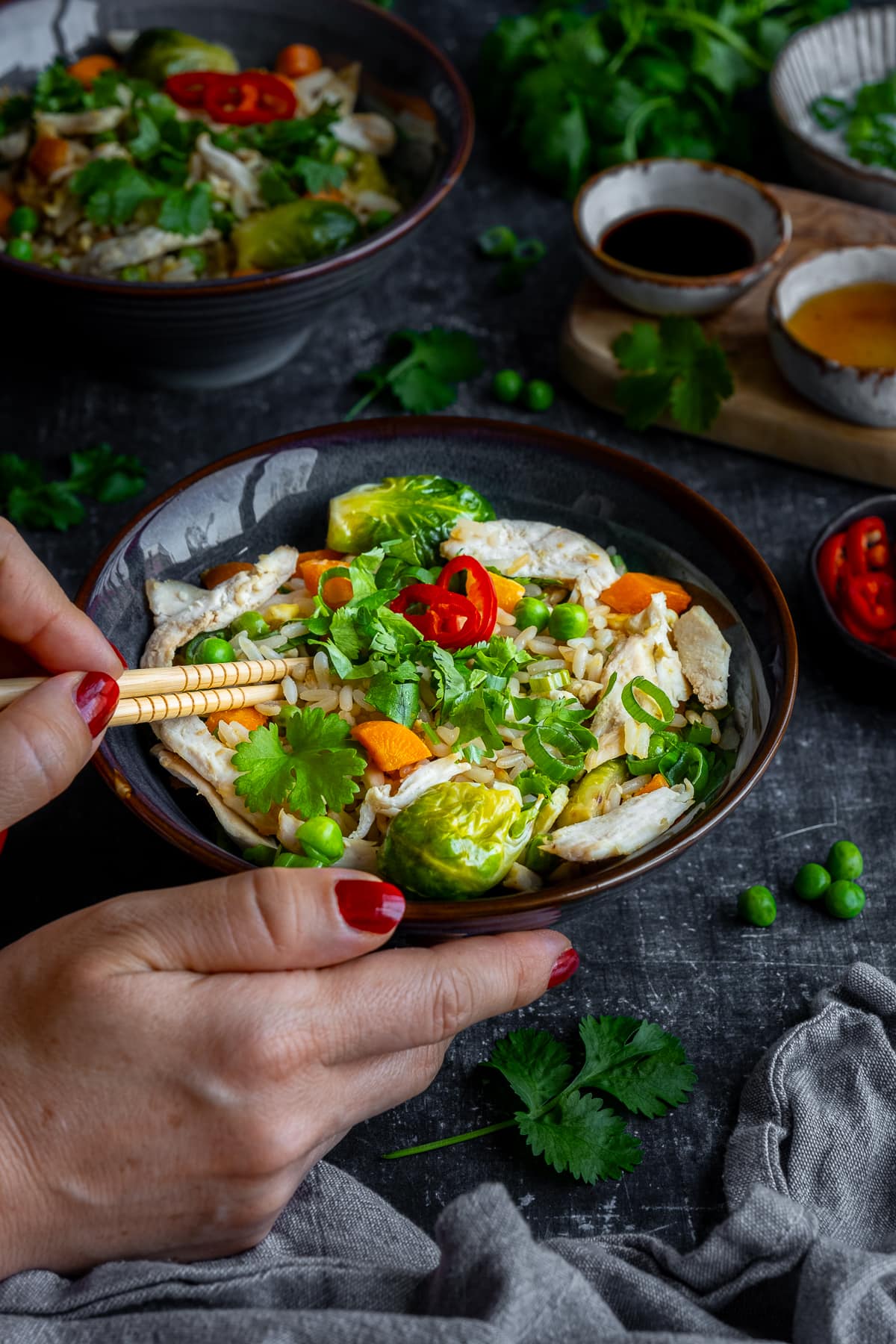 Woman's hands holding chopsticks eating Leftover Turkey Fried Rice 