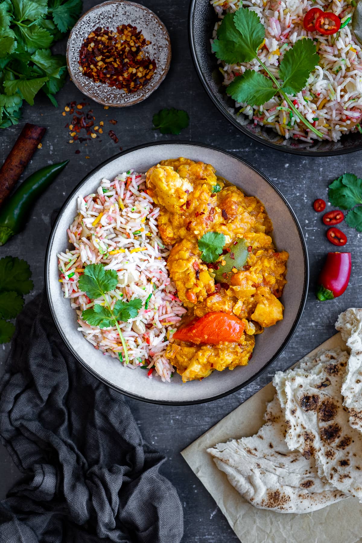 Overhead shot of Multicoloured Pilau Rice in a bowl with chicken dhansak