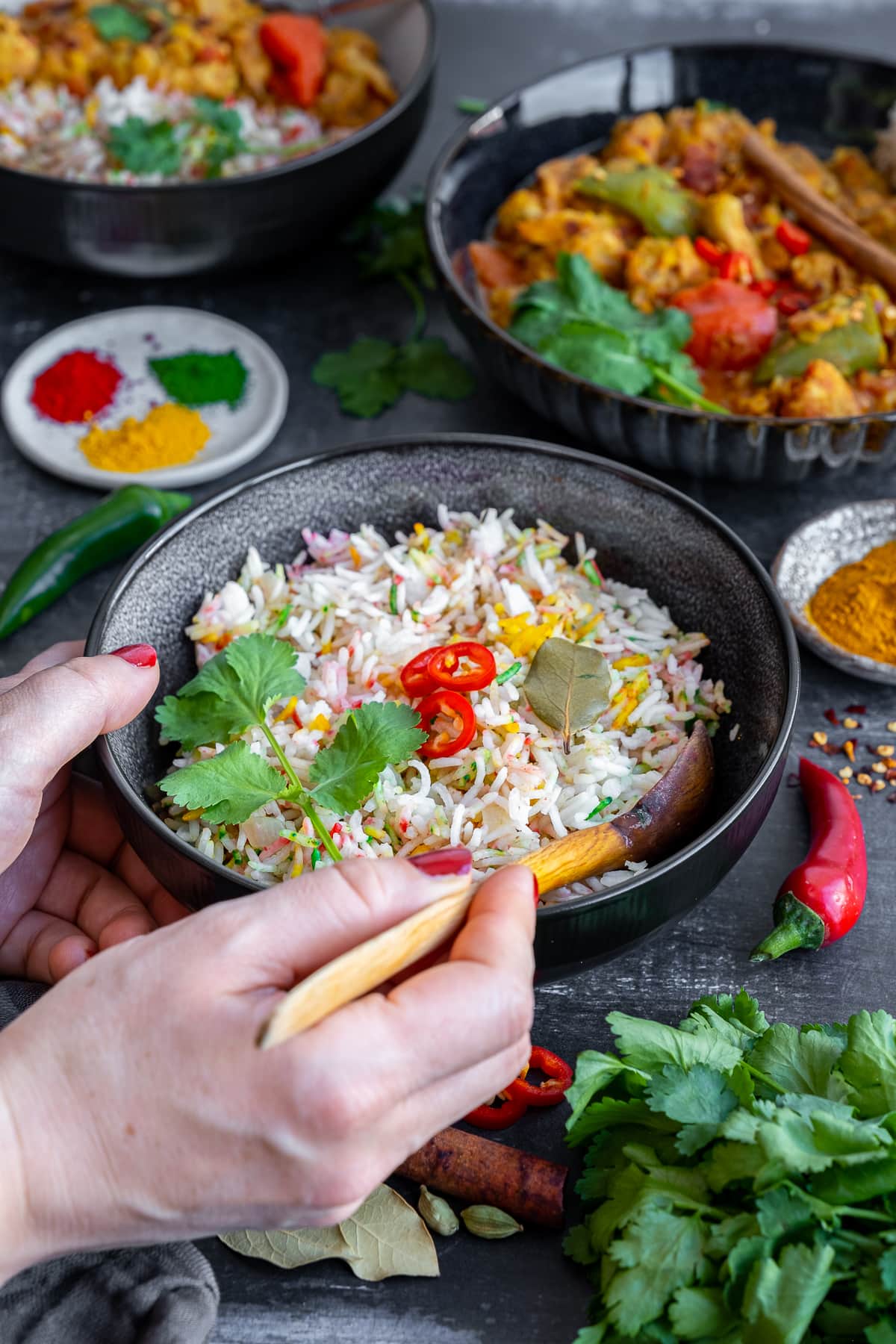 Multicoloured Pilau Rice with chicken dhansak in the background