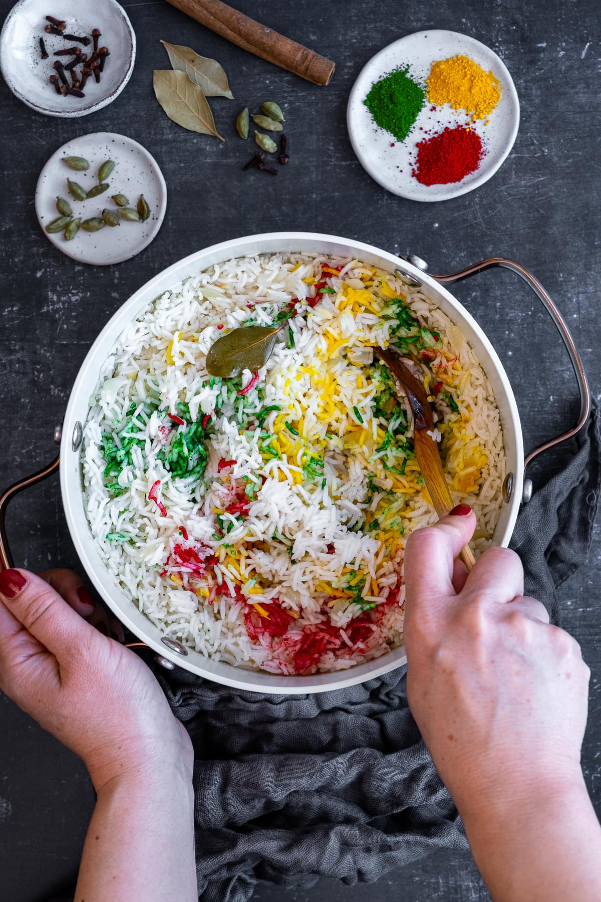 Red, Green and Yellow edible coloured powders being mixed into Multicoloured Pilau Rice