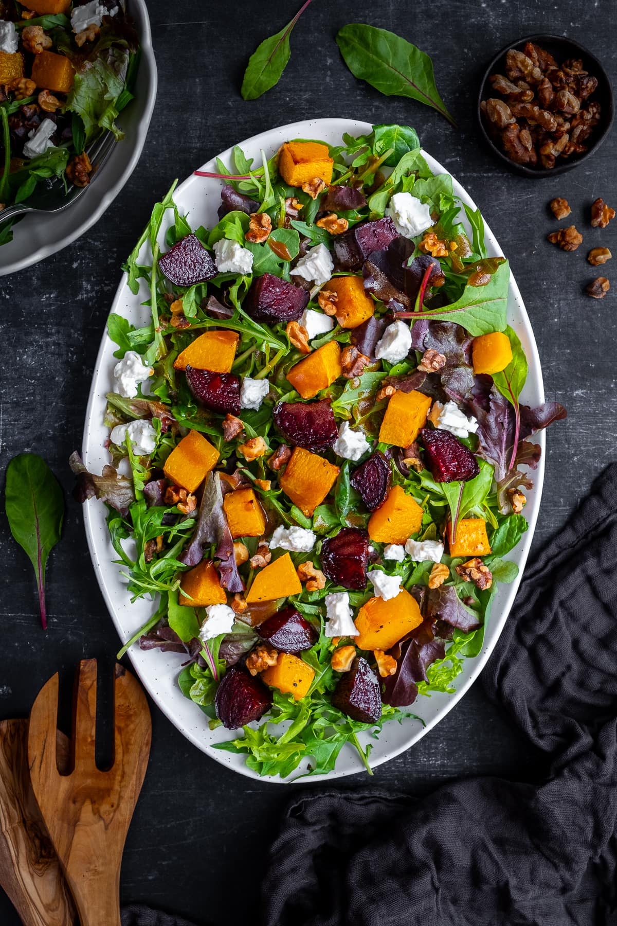 Overhead shot of Roasted Butternut Squash and Beetroot Salad with Feta and Walnuts in an white oval serving dish