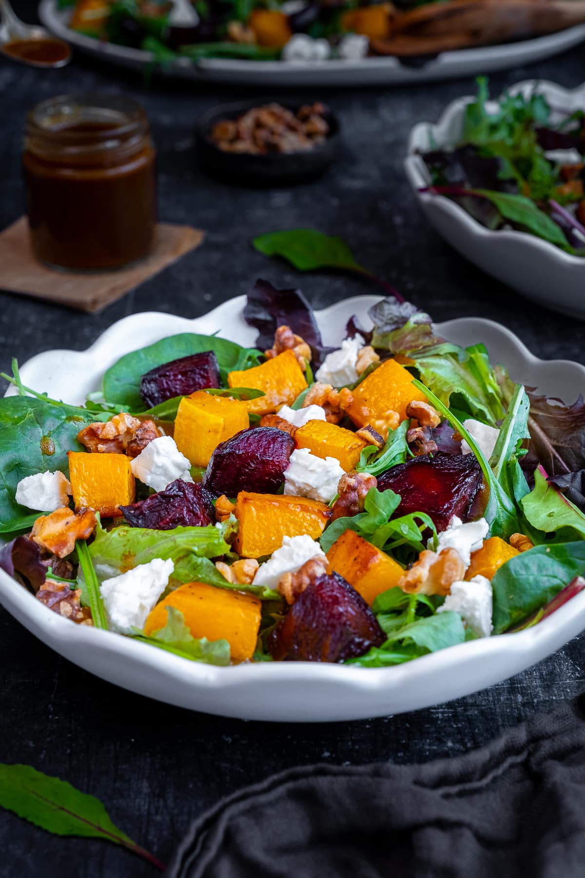 Eye level view of Roasted Butternut Squash and Beetroot Salad with Feta and Walnuts in a serving dish