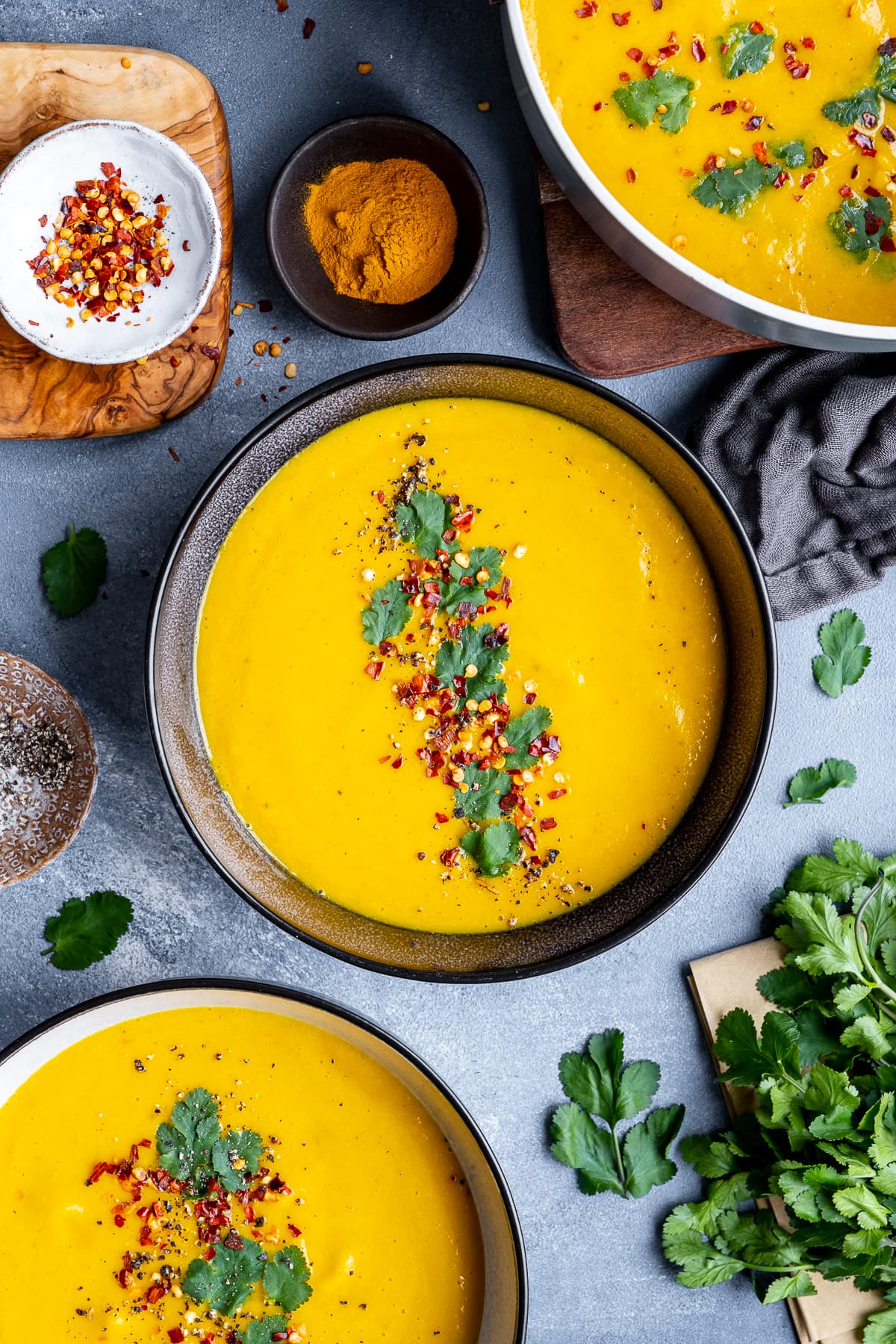 Overhead shot of 3 bowls of Spiced Carrot and Lentil Soup