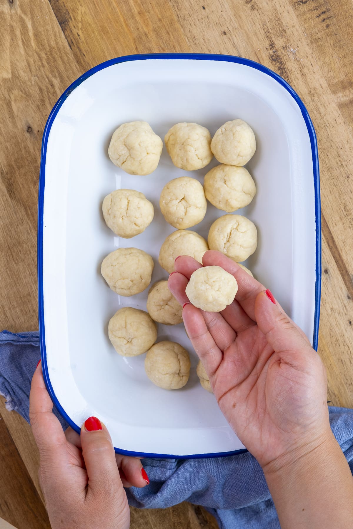 Raw suet dumplings - one of which is being held up to the camera