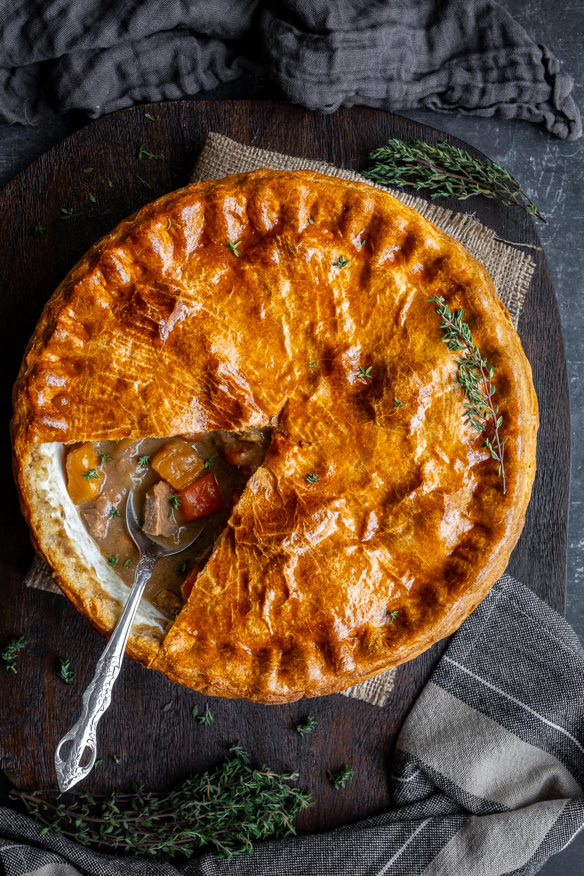 Overhead shot of Traditional Suet Crust Steak Pie. One portion cut out to reveal the filling inside